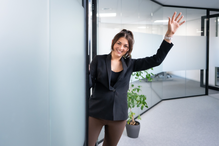 Chloë zwaait vanuit haar kantoor in Hoofddorp